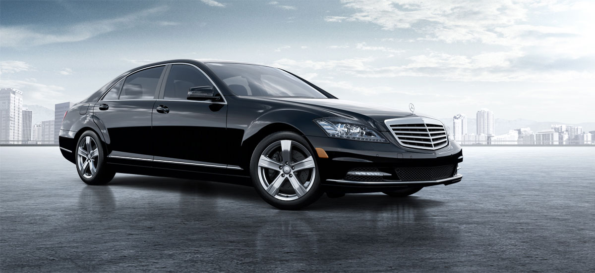 Black Mercedes S550 sedan in front of a city skyline